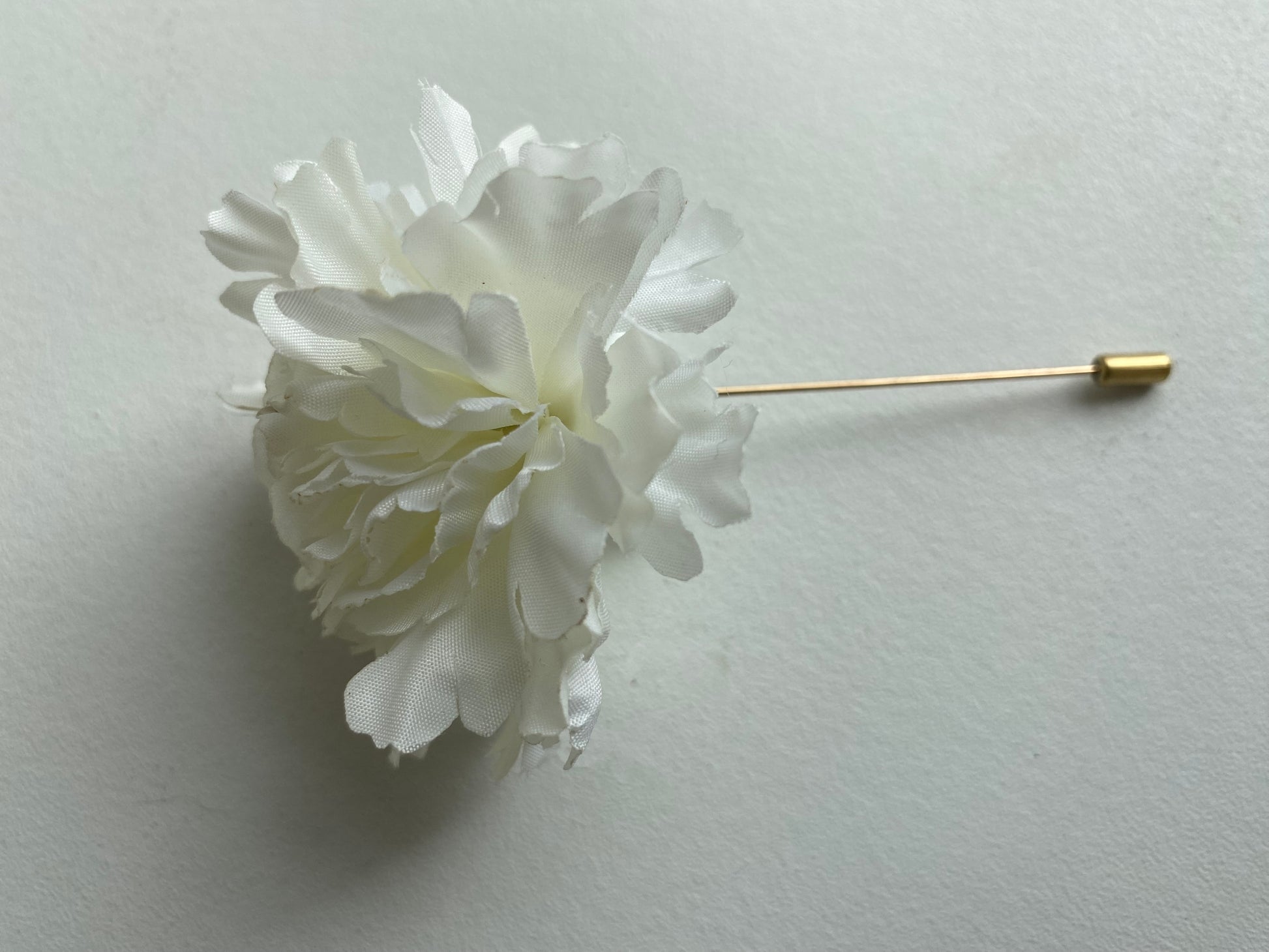 white carnation buttonhole lapel pin wedding formal occasion