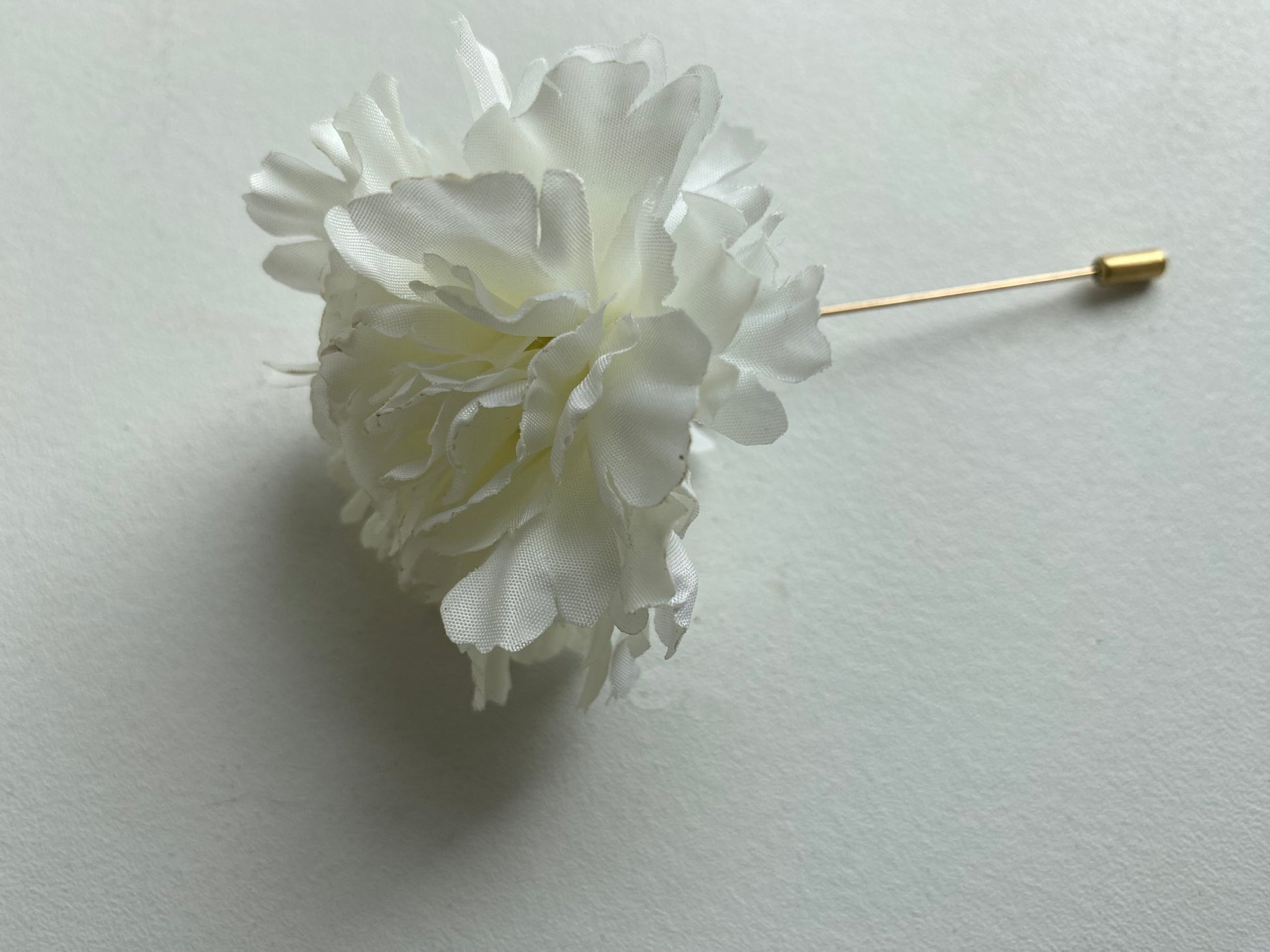 white carnation buttonhole lapel pin wedding formal occasion