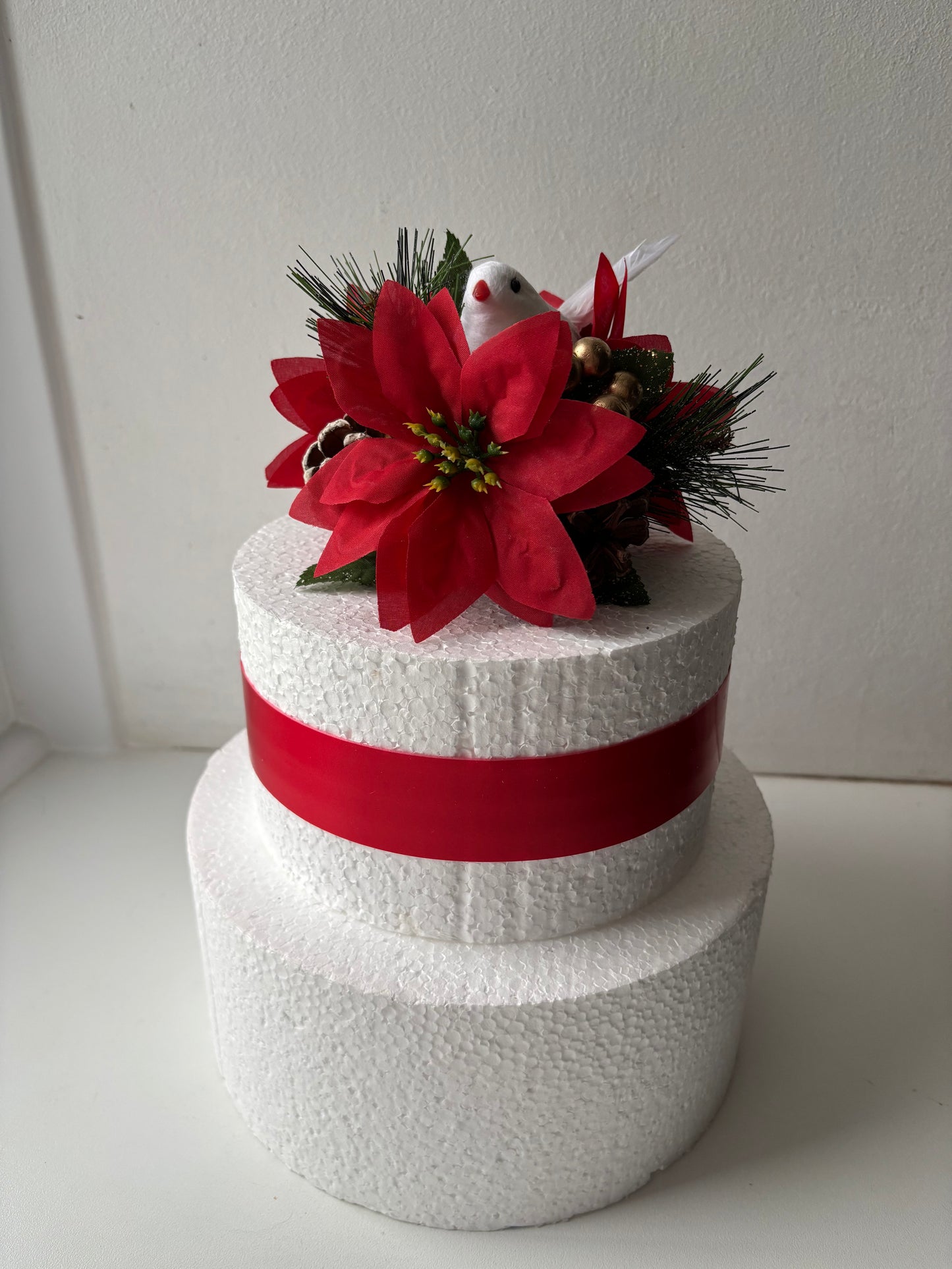 Decorative festive cake topper with red flowers and a cute white dove.