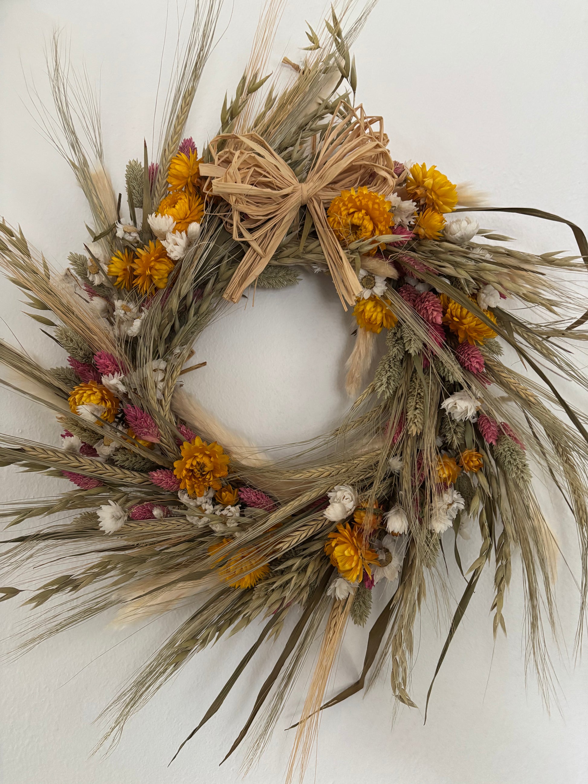 Hanging dried flower wreath with bow. Yellow, white, pink, ivory and pale green