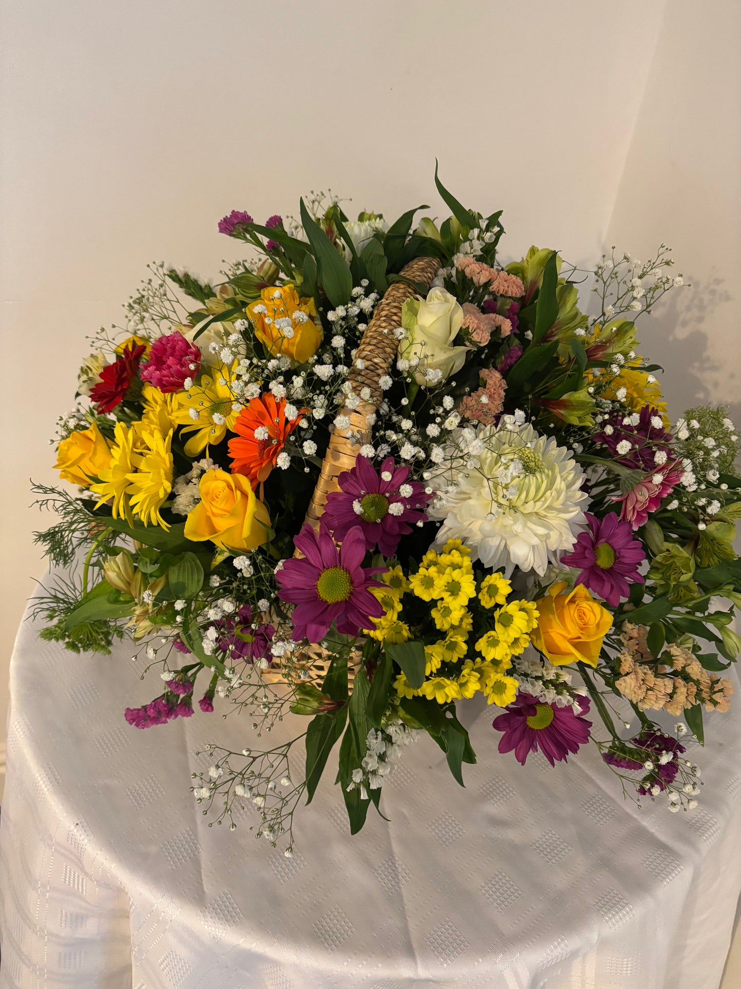 Fresh seasonal mixed colourful flowers in a wicker basket