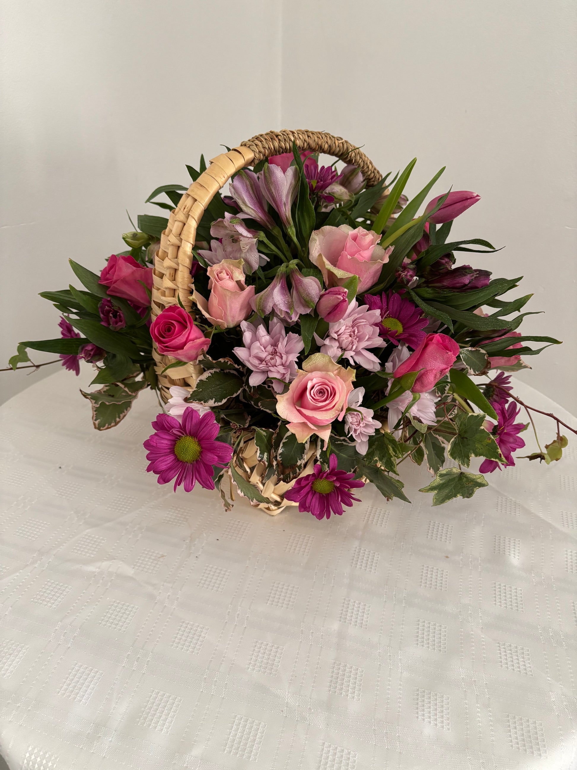 Shades of pink fresh flowers in wicker basket