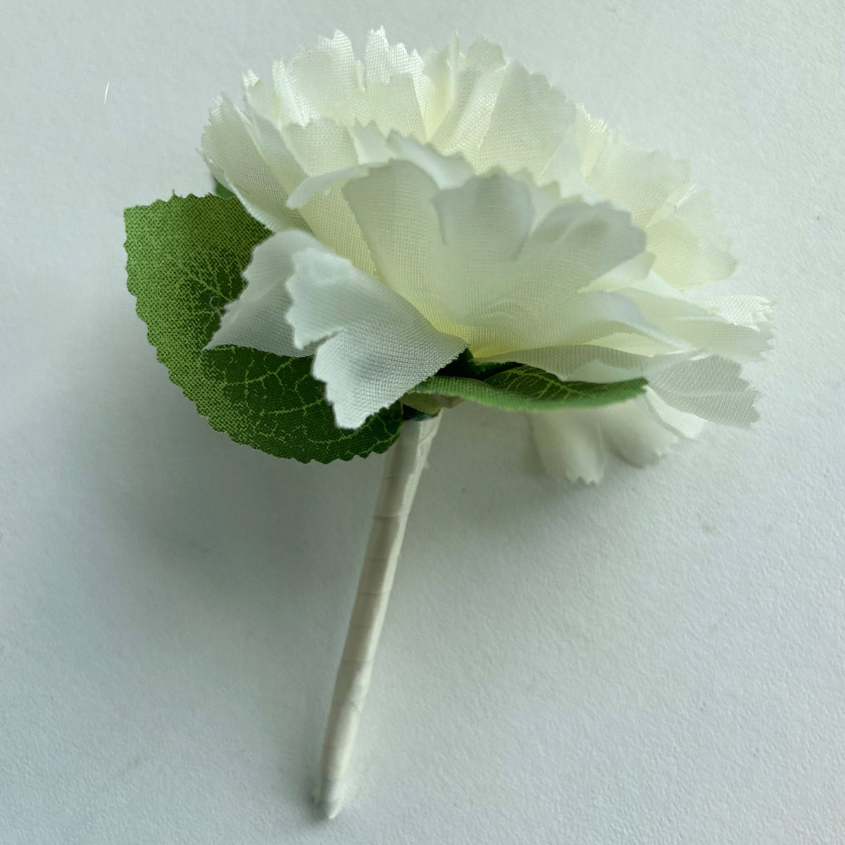 Cream carnation buttonholes with ribbon handle
