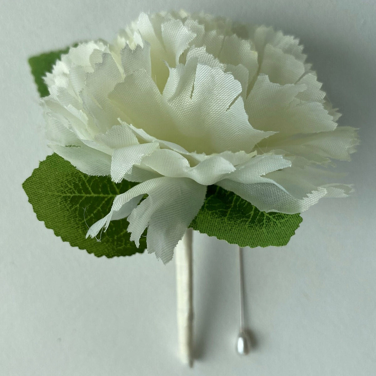 Cream carnation buttonholes with ribbon handle