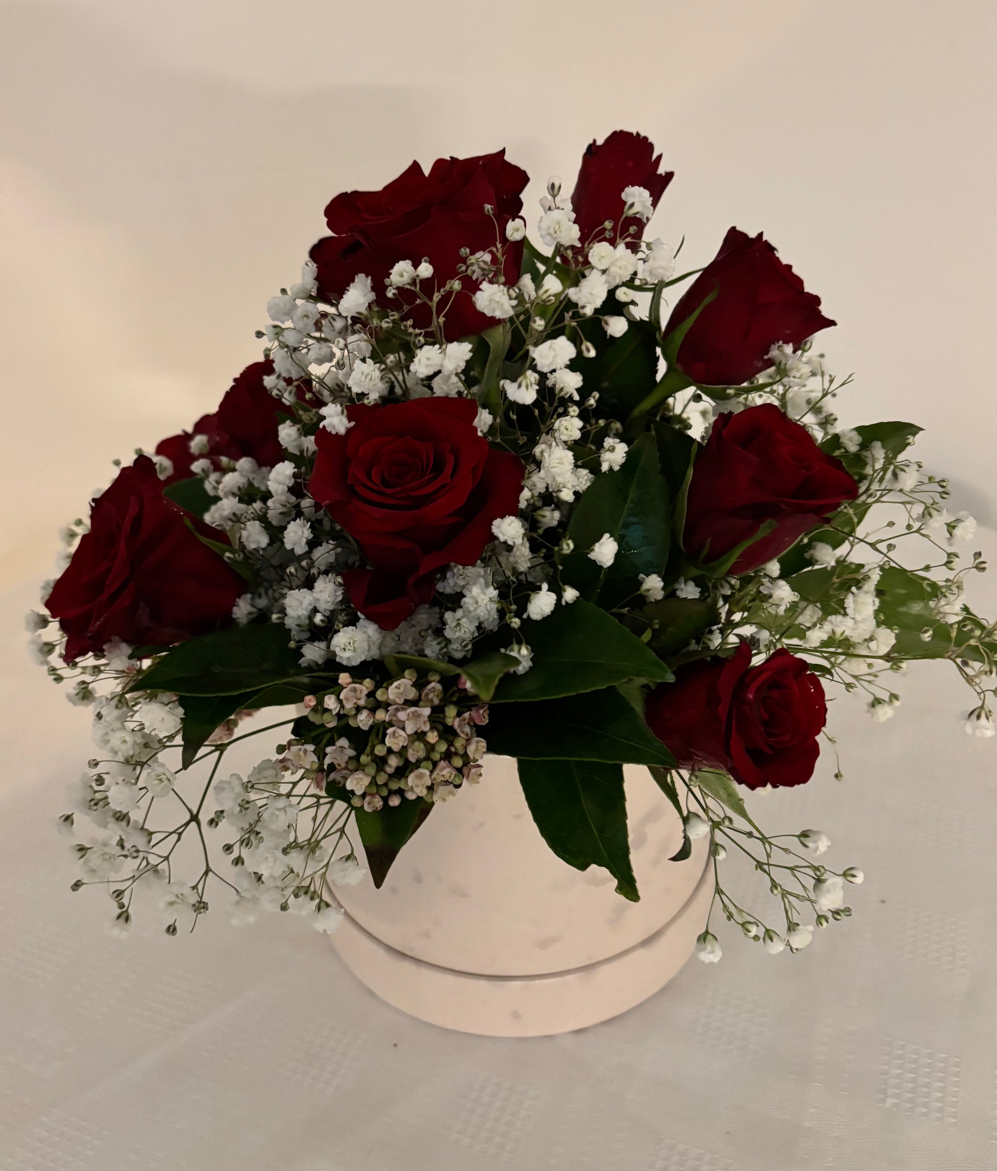 Red roses and Gypsophila arranged in a hatbox