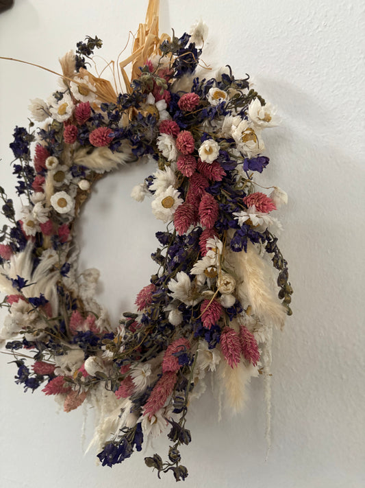 Side view of pink, blue and white dried flower wreath