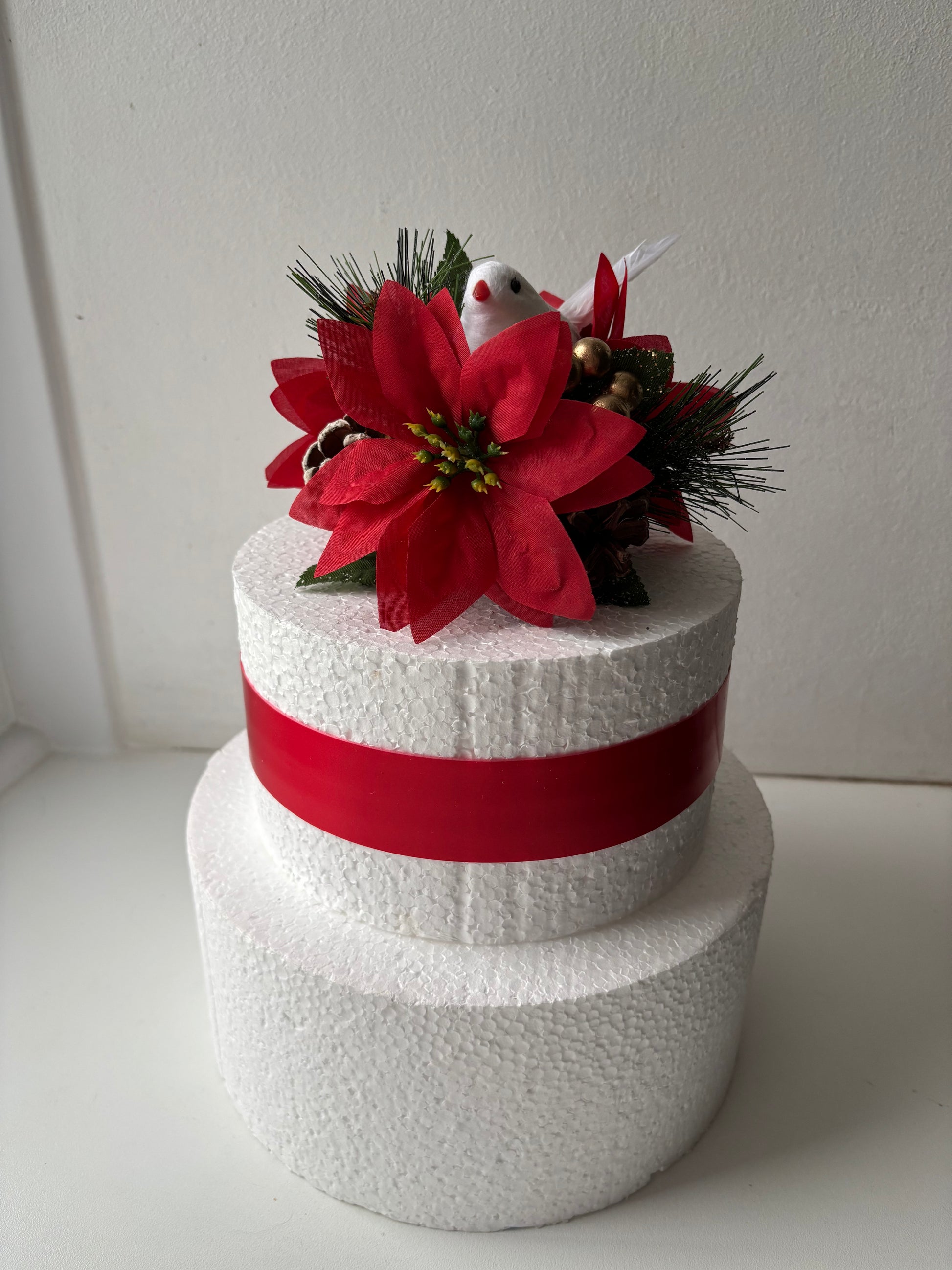 Decorative festive cake topper with red flowers and a cute white dove.