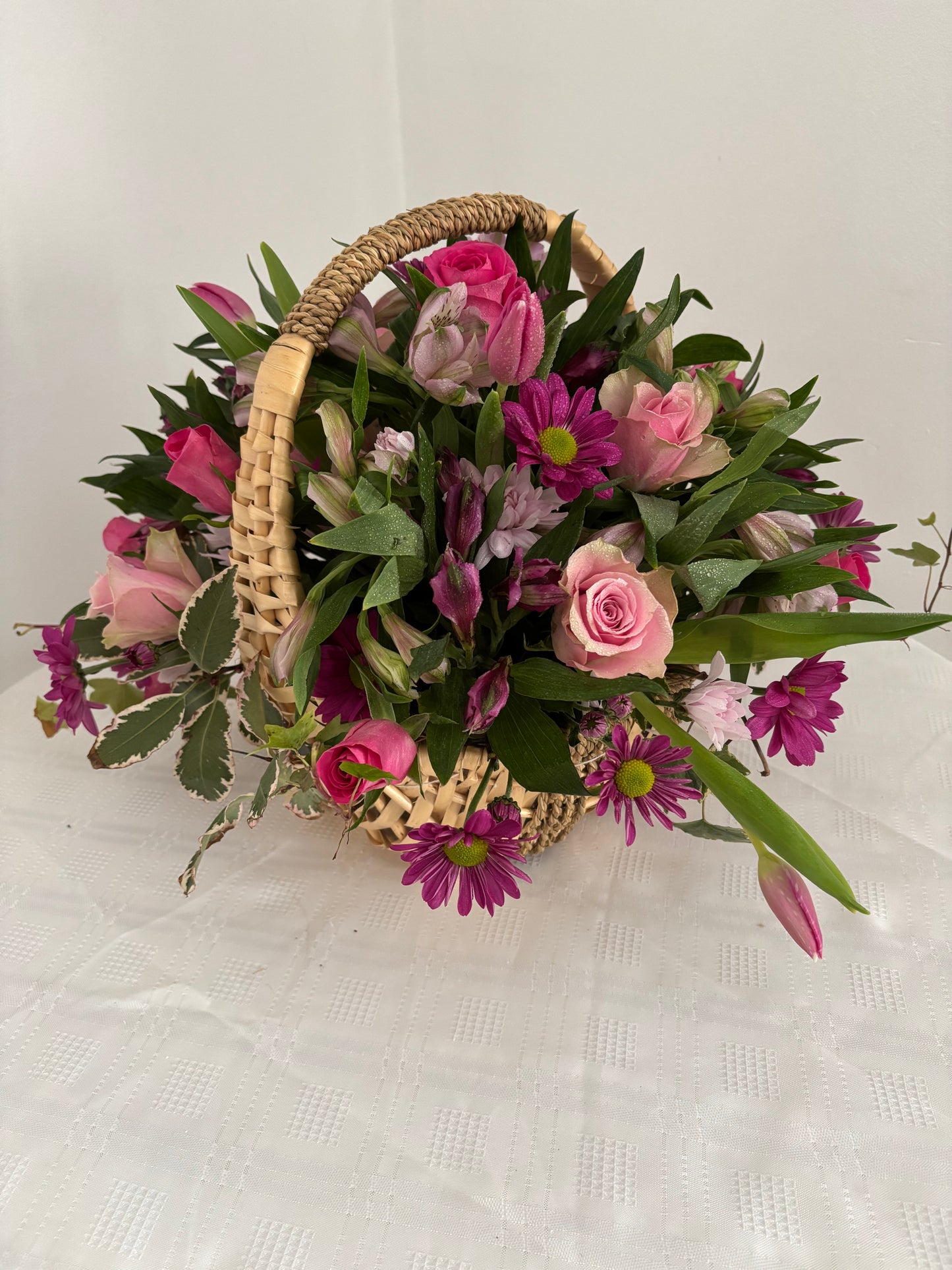 Fresh flowers in shades of pink arranged in a basket