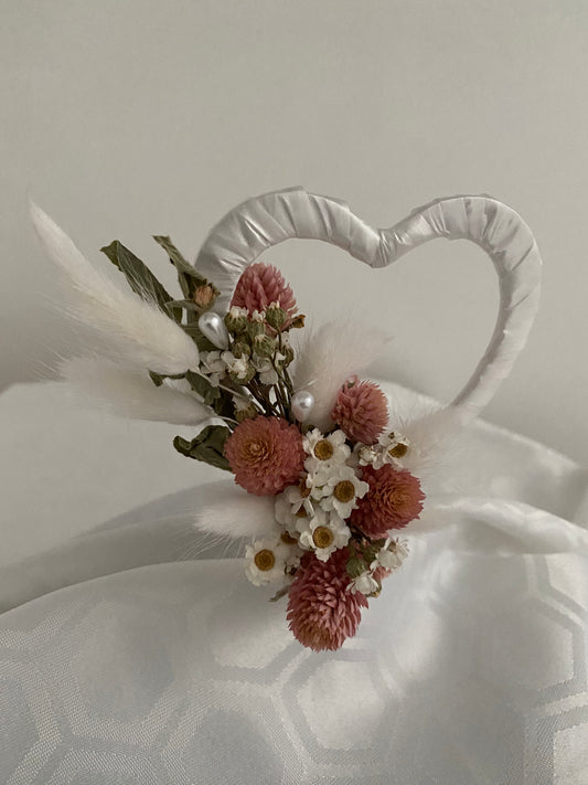 Hand made cake topper decoration using pale pink and white dried flowers with small pearl effect decoration