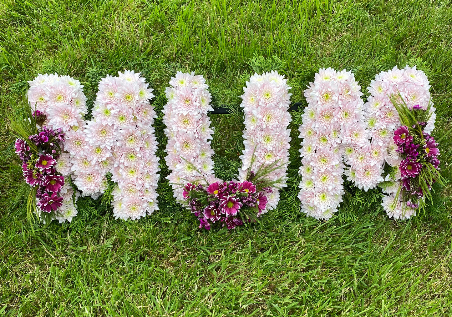 MUM Floral Funeral Tribute with Pale lilac/pink base flowers.