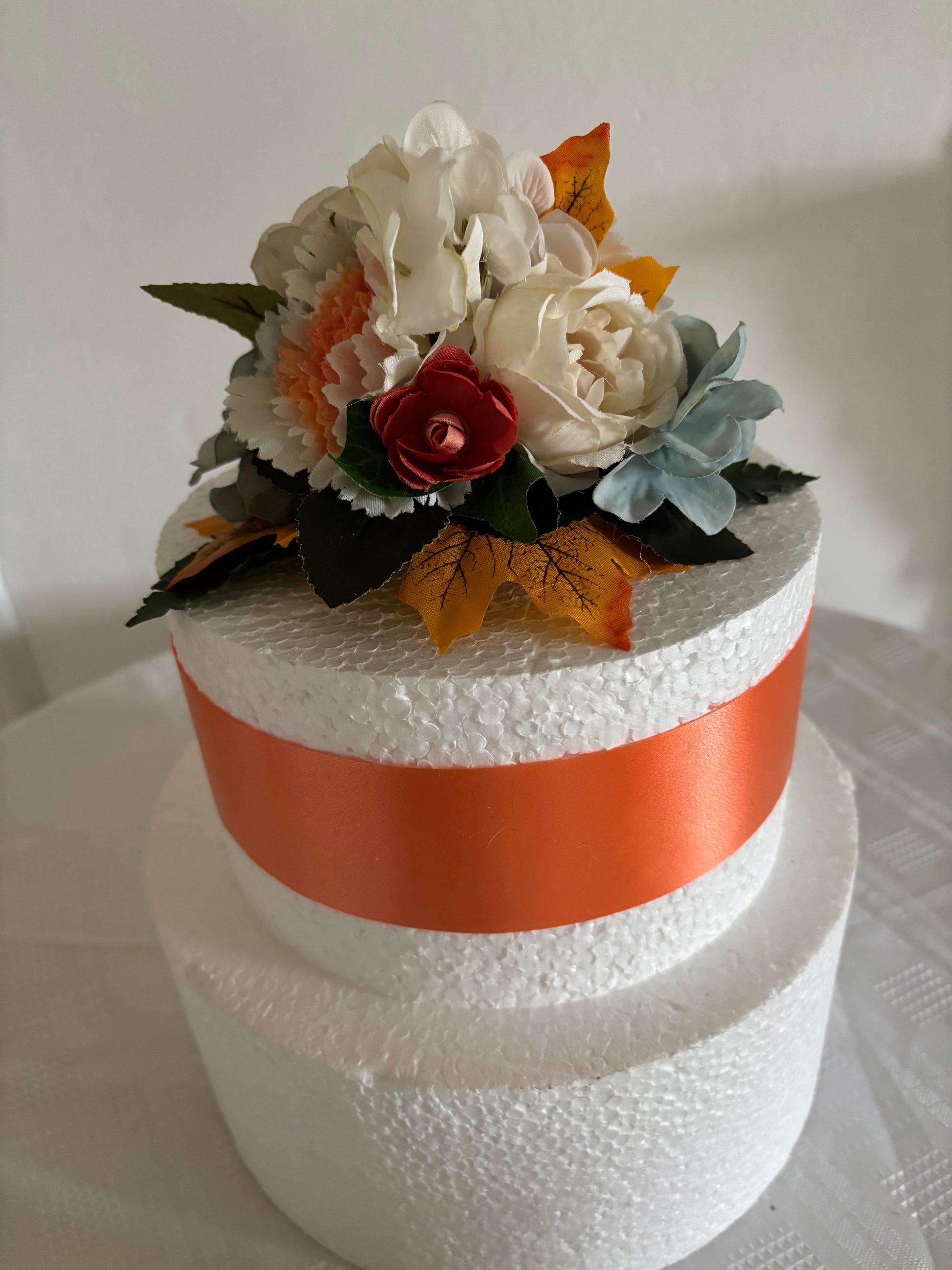 Warm orange and pale blue silk flower cake topper