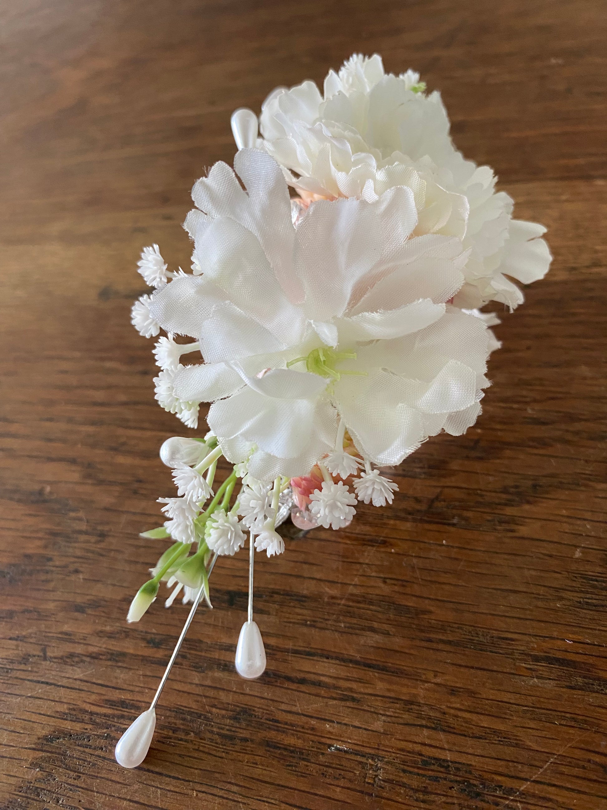 Silver metal hair comb with pink and white flowers.